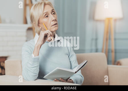My work. Pleasant smart woman taking notes while working at home Stock Photo