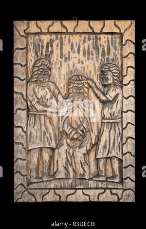 Naive or folk wood carving bas relief plaque representing the biblical crowning of Jesus with thorns subject. Isolated on black. Stock Photo