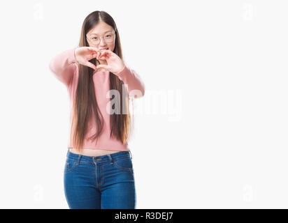 Young Chinese woman over isolated background wearing glasses smiling in love showing heart symbol and shape with hands. Romantic concept. Stock Photo