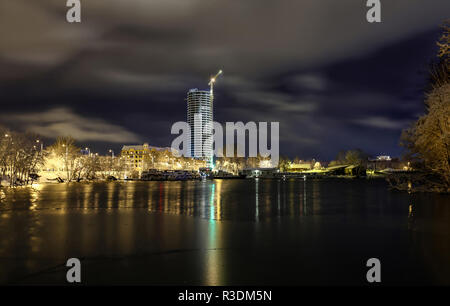 View of Riga, Latvia in winter night with skyscrapers and bay of Daugava river with beautiful clouds Stock Photo