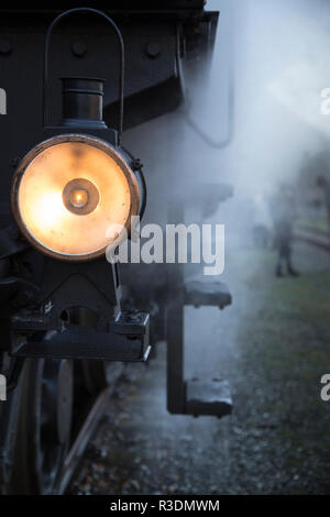 An old lamp of a steam locomotive shines to forward on track. Retro ...