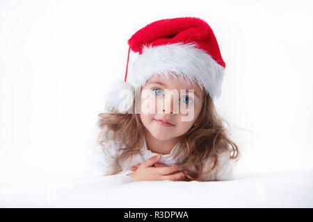 Christmas time, little girl in Santa Claus hat smilling. Stock Photo