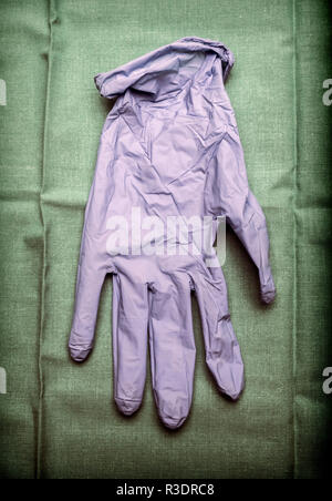 Glove of latex blue on green cloth in an operating theater, conceptual image Stock Photo