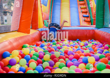 Inflatable castle full of colored balls for children to jump Stock Photo