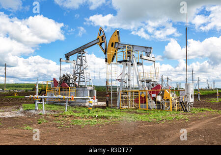Nurlat, Russia - June 10, 2018: Working pump jack fracking crude extraction machine. Oil industry equipment Stock Photo
