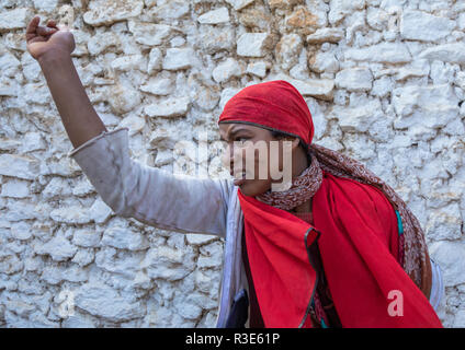 Sufi woman with a red veil into trance during a muslim ceremony, Harari Region, Harar, Ethiopia Stock Photo