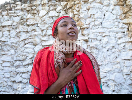 Sufi woman with a red veil into trance during a muslim ceremony, Harari Region, Harar, Ethiopia Stock Photo