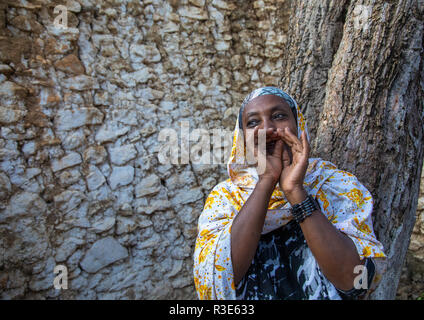 Veiled harari woman making ululation during a muslim ceremony, Harari Region, Harar, Ethiopia Stock Photo