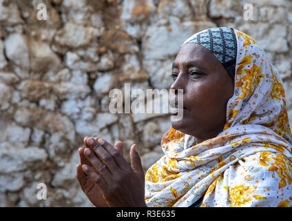 Veiled harari woman clapping her hands during a sufi ceremony, Harari Region, Harar, Ethiopia Stock Photo