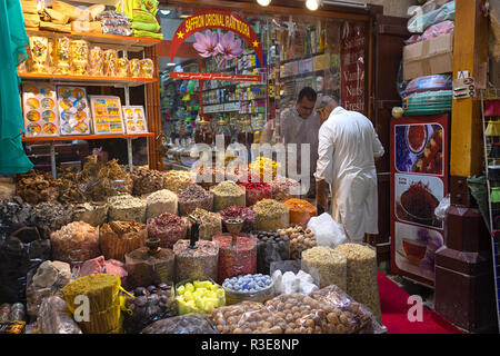 DUBAI, UAE - November 09, 2018: Merchant selling spices to client in Dubai spice souk in Deira district. Traditional spices shop in old town Stock Photo