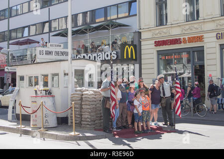 BERLIN, GERMANY - AUGUST 25, 2016: Tourists Posing At Historic US Army Checkpoint Charlie In Berlin, Germany Stock Photo
