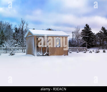 Small storage shed in a winter landscape. Stock Photo