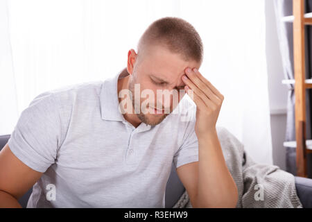 Portrait Of A Young Man Suffering From Headache At Home Stock Photo
