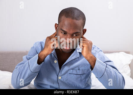 Close-up Of A Young African Man Covering His Ears With Finger Stock Photo