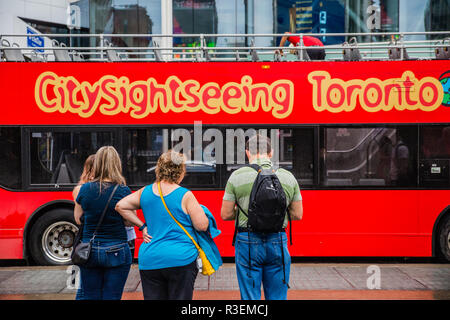 tourists lining up for toronto sightseeing bus red double decker tour bus Stock Photo