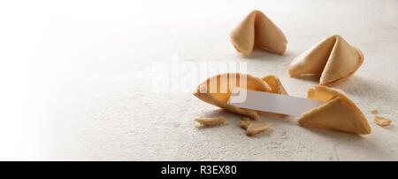 chinese fortune cookies with a blank paper slip for the prediction, panoramic format, bright background fades to white, copy space, selected focus, na Stock Photo