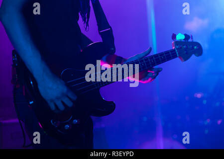 Live rock music background, bass guitar player on a stage, close-up photo with soft selective focus Stock Photo