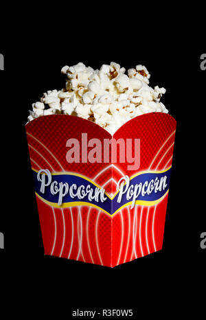 Filled red popcorn box on black background. Stock Photo