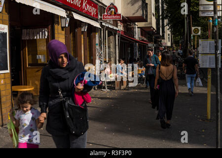 People relaxing outside in the sun at a cafe in Neukolln, Berlin, Germany. Stock Photo