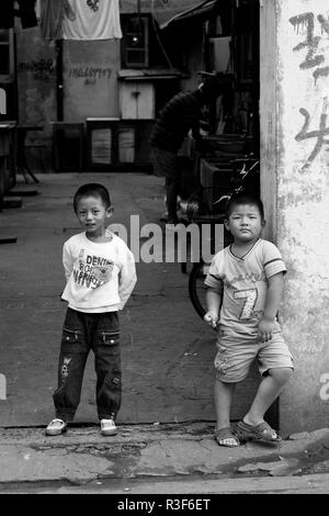 Two curious boys in ''their'' street in Shanghai, China. Stock Photo
