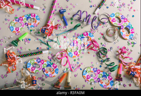 Carnival or birthday party. Confetti and serpentines on pastel grey background, top view Stock Photo