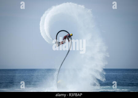 Dugi Rat, Croatia - October 20, 2018: A man is doing acrobatics with flyboard attached to jet ski close to the shore in Dugi Rat, Croatia. Stock Photo