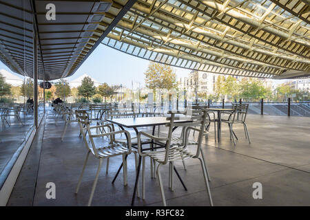 A cafe terrace in the patio of the Forum des Halles underground shopping mall in the center of Paris, France, covered by a vast glass and steel canopy Stock Photo