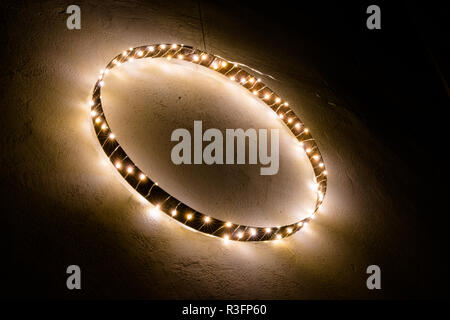 simple minimalist and effective Christmas decoration ornament wall hanging of metal ring with chain of lights Stock Photo