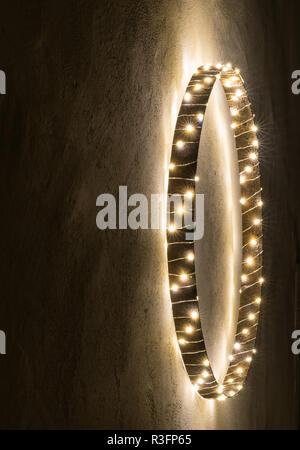 simple minimalist and effective Christmas decoration ornament wall hanging of metal ring with chain of lights Stock Photo