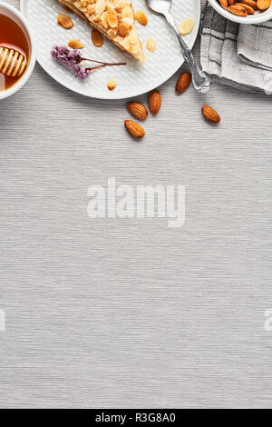 Sliced apple and almond pie on plate over the grey tablecloth. Top view with copy space for text. Stock Photo