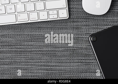 Business composition with white computer keyboard, mouse and black phone on grey background. Top view with copy space for text. Stock Photo