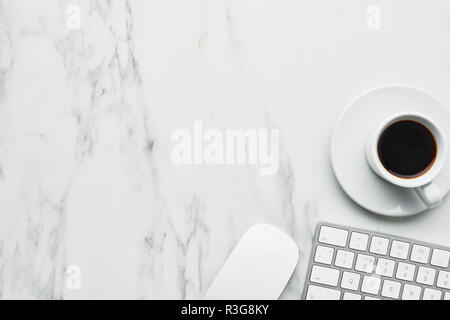 Business composition with white computer keyboard, mouse and coffee cup on white marble background. Coffee break concept. Top view with copy space for Stock Photo