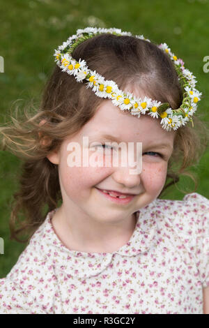 Six-year-old girl with a daisy chain on her head in the shape of a crown. UK (98) Stock Photo