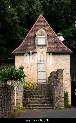 traditional style stone built house with a forest behind in the Dordogne, France Stock Photo