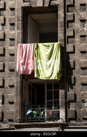 washing hanging from a window in a stone or concrete building Stock Photo