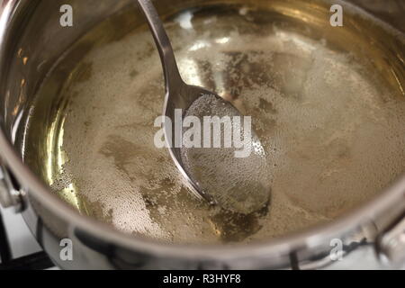 Boiling and Mixing Cider in Pan on Gas Stove. Making Cider Pie Series. Stock Photo