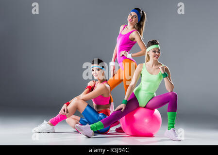 beautiful athletic women in 80s style sportswear posing together on grey  Stock Photo - Alamy