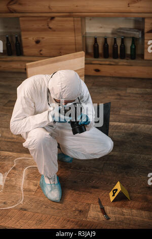 forensic investigator documenting evidence with camera at crime scene ...