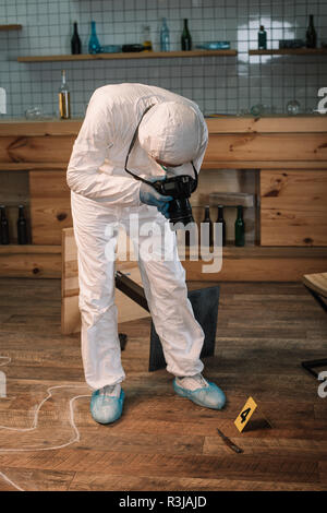 Forensic expert with camera taking photo of evidences at crime scene ...