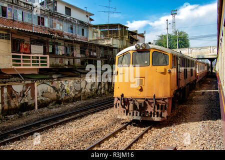 The train ride through city in Thailand. The train leaves the railway station in Bangkok. Stock Photo