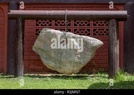 Decorative boulder hanging on a chain in Buddhist temple, Thailand. Lucky rock. Stock Photo