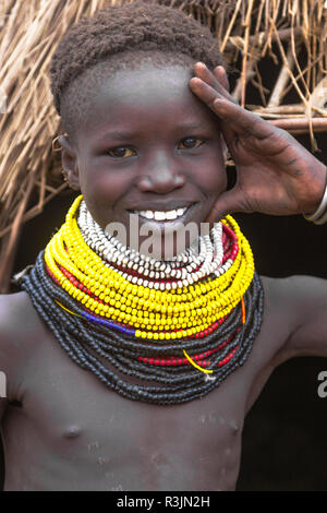 Nyangatom tribe girl in front of a school wall depicting animals ...