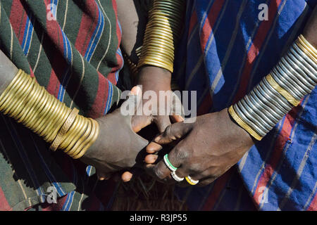 Mursi tribe, people in traditional clothing wearing bracelets, Mursi Village, South Omo, Ethiopia Stock Photo