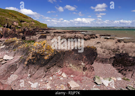 Red rocks on the shore at Youghal, County Cork, Ireland Stock Photo