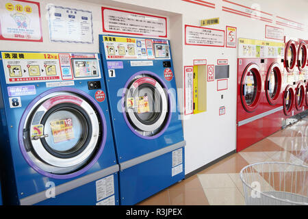 Row of industrial washing machines in a public laundromat Stock Photo