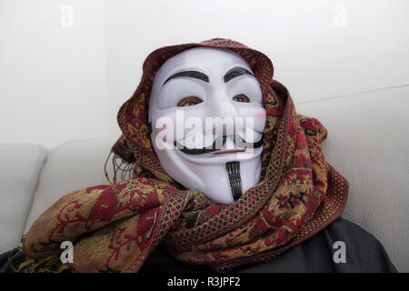 hacker on the couch at home,anonymous mask Stock Photo