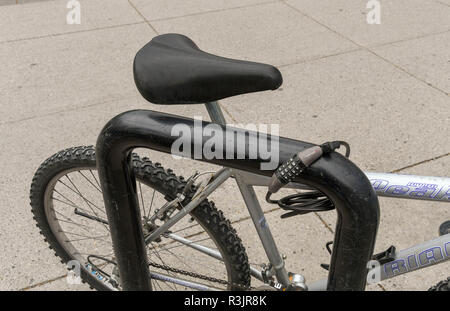 BANFF, AB, CANADA - JUNE 2018: Close up view of a bicycle locked to a cycle rack in Banff town centre Stock Photo