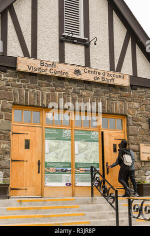 BANFF, AB, CANADA - JUNE 2018: Visitors opening the door to enter the Banff National Park Visitor Centre in Banff town. Stock Photo