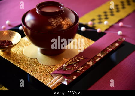 Japanese traditional New Year's tableware showing a bowl and chopsticks and a beautiful gold mat Stock Photo