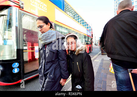 Mother and daughter by a bus in central London, England, UK. Winter Stock Photo